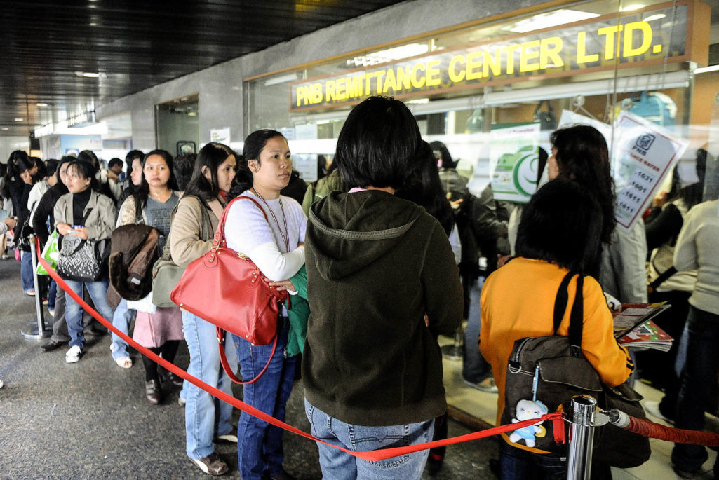 Filipino domestic helpers line up to send money at a remittance center in the central district of Hong Kong,