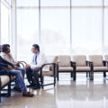 Doctor discussing with family while sitting hospital waiting room