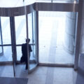 Businessman leaving the revolving door of the office building.