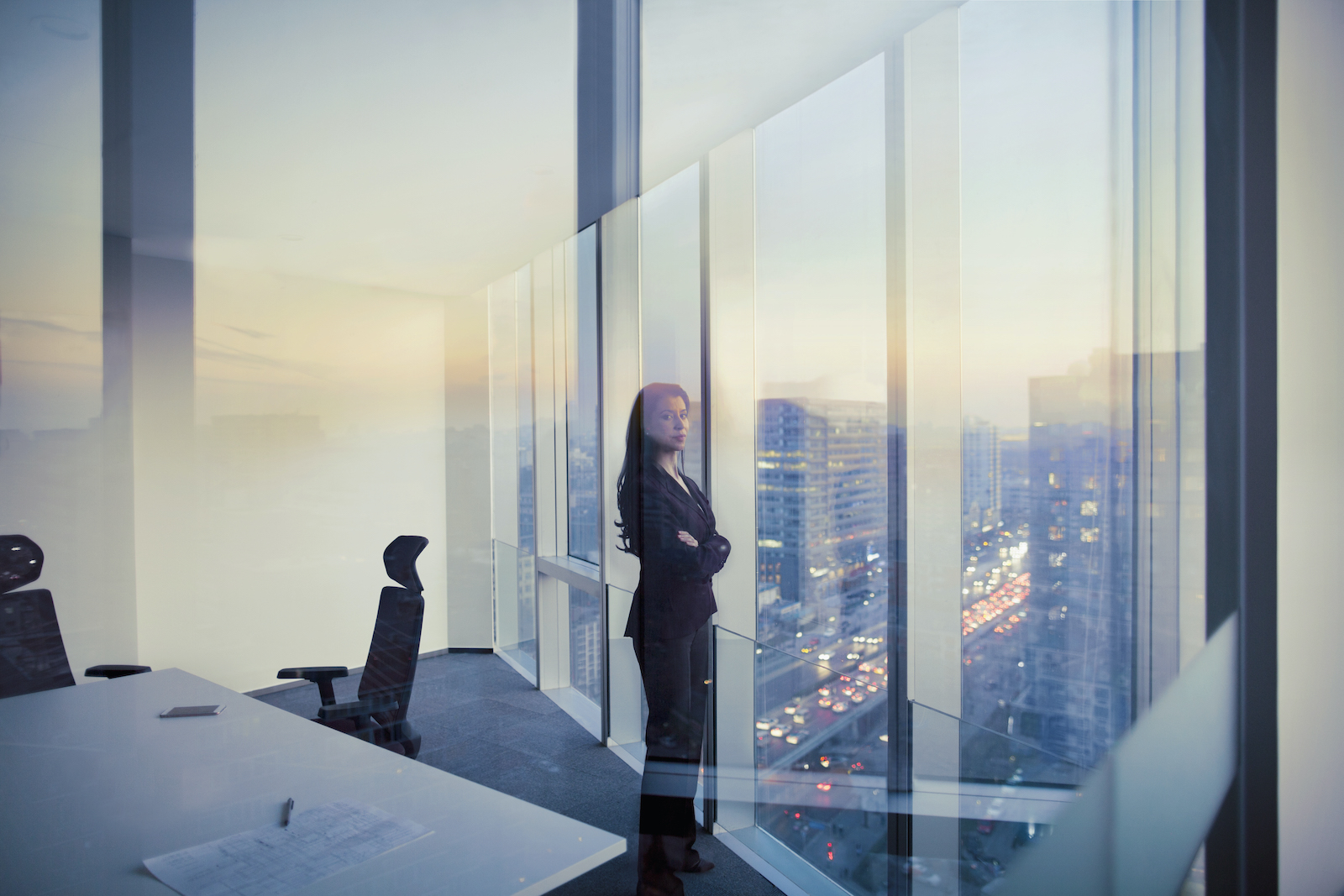 Adult Hispanic woman CEO executive businesswoman business person in conference meeting room in contemporary modern office daylight sunset dusk talking planning thinking strategy well dressed suit diversity multi-ethnic problems solutions unity cityscape downtown urban new beginnings breaking new ground decisions choices the way forward contemplation vision focus choices decisions solitude quiet alone