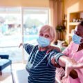 Close up of a young female caregiver doing physical therapy on her patient