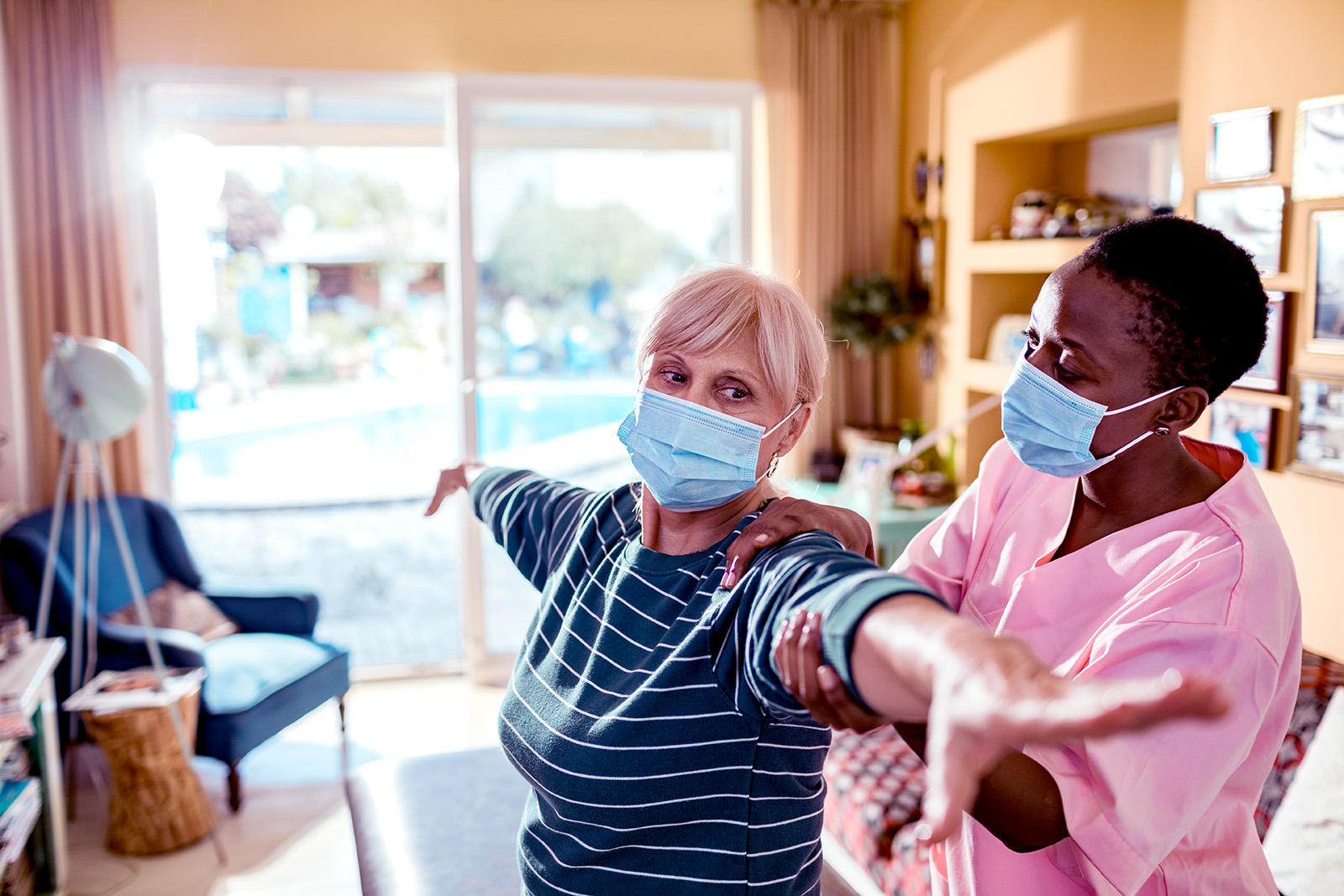 Close up of a young female caregiver doing physical therapy on her patient
