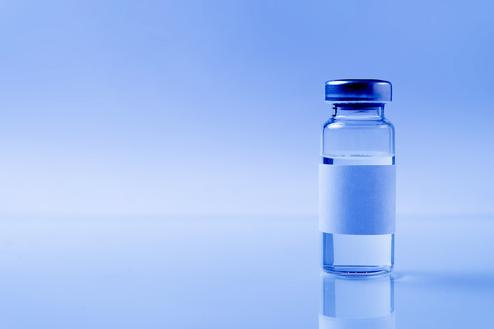 a glass medical bottle or ampoule with a vaccine for covid-19 or for colds and flu on a white background. The concept of treatment and prevention of the spread of infection, virus and pneumonia.