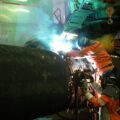 A photo of a worker welding two pipes together