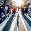 A photo of people crossing a busy city crosswalk.