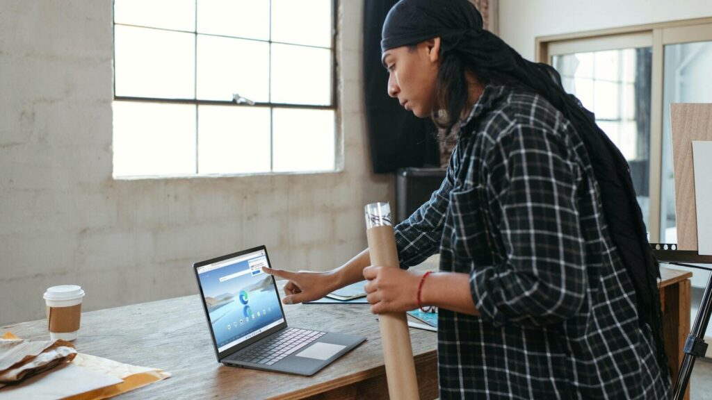 A photo of a woman leaning over a laptop on a desk