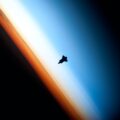 A photo of the Space Shuttle Endeavour from space, silhouetted against Earth