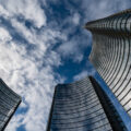 A view of skyscrapers from below, with a sunny sky