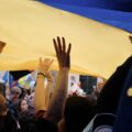 Photo of hands holding up the Ukrainian flag