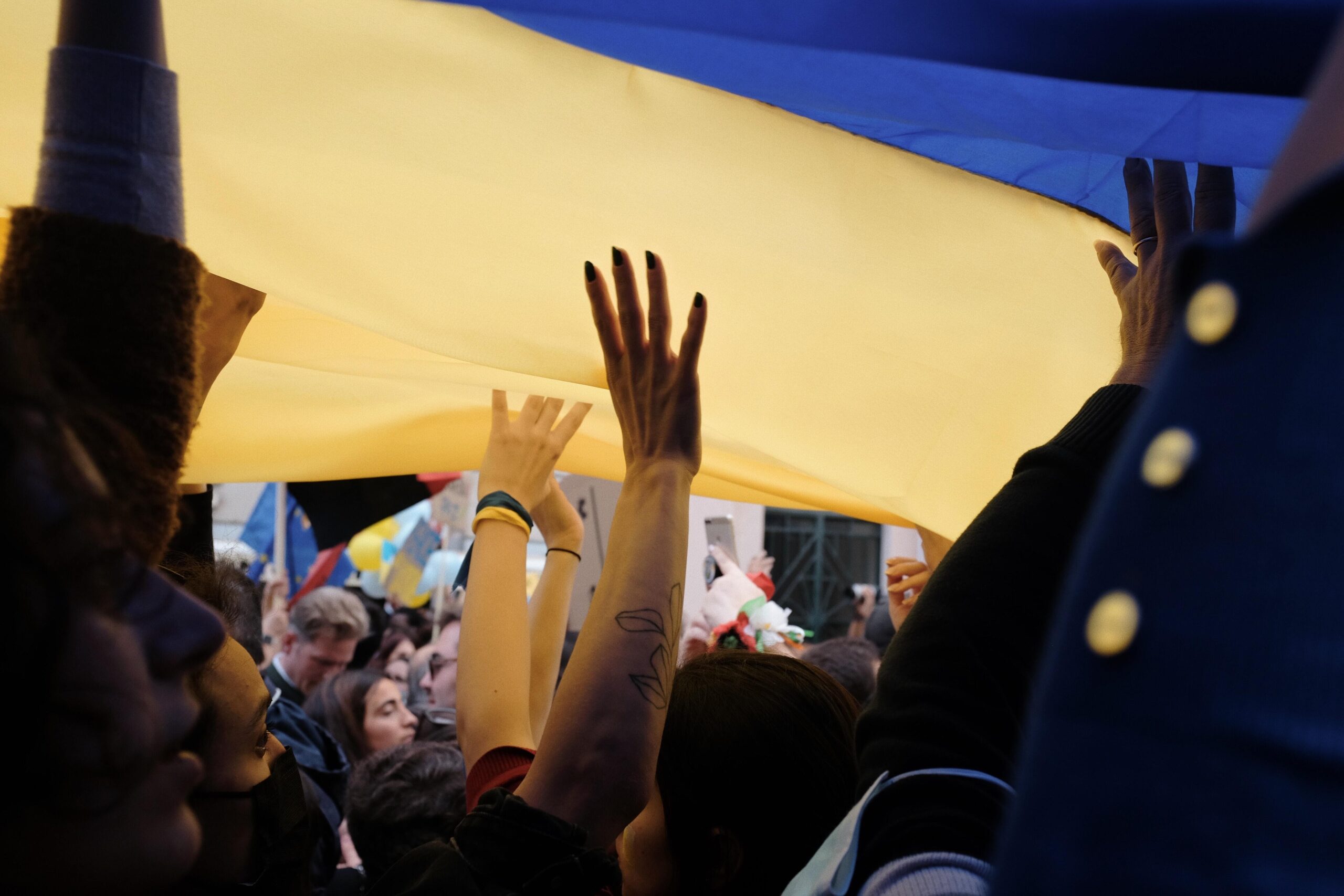Photo of hands holding up the Ukrainian flag
