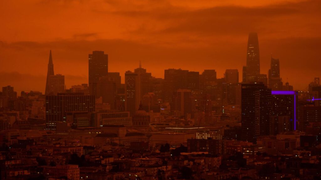 A red haze and smoke from wildfires nearly obscure the city outline of San Francisco.