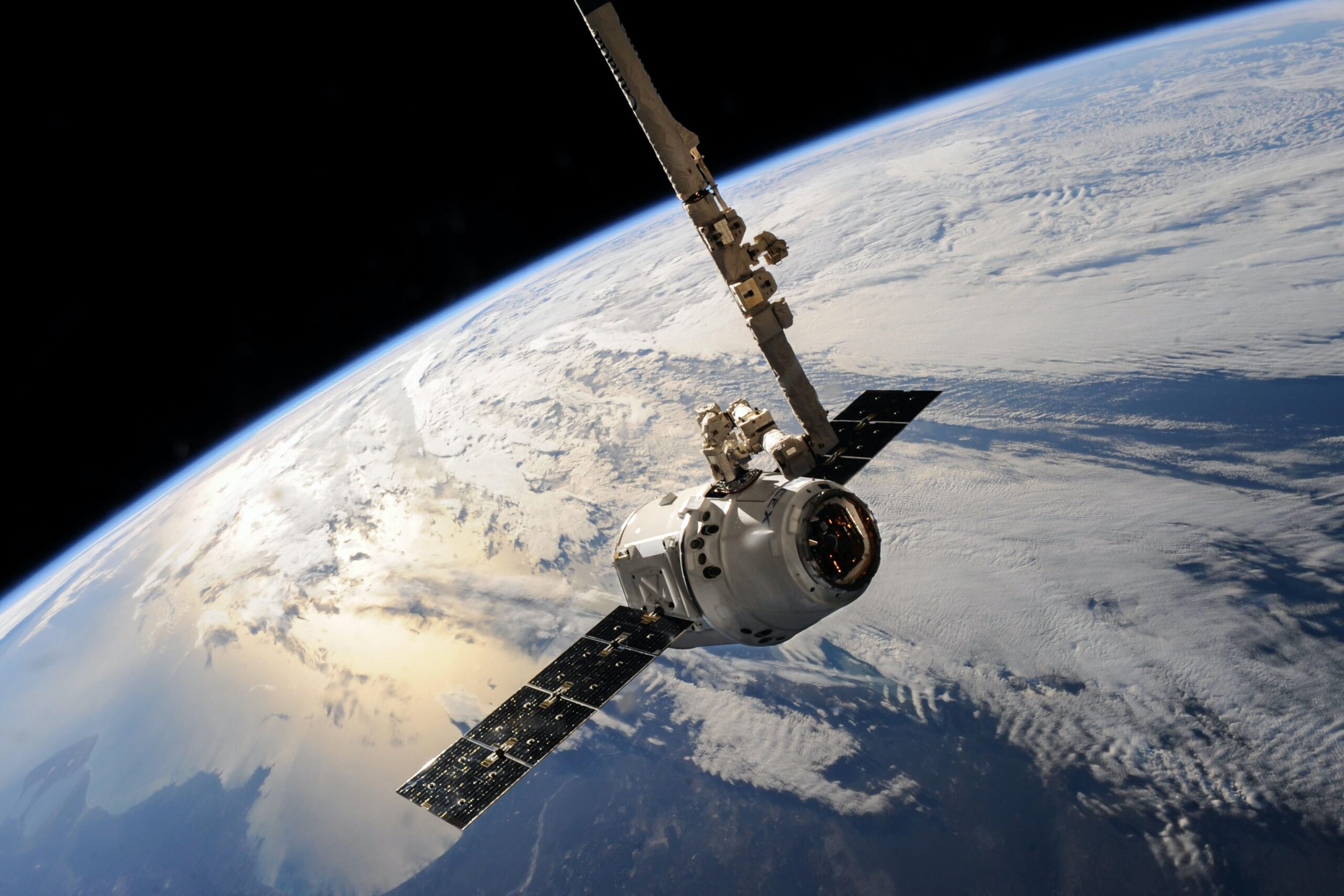 A view of a SpaceX satellite from behind orbiting the curve of the Earth