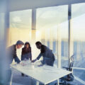 Business people gather in a conference meeting room to discuss a plan.