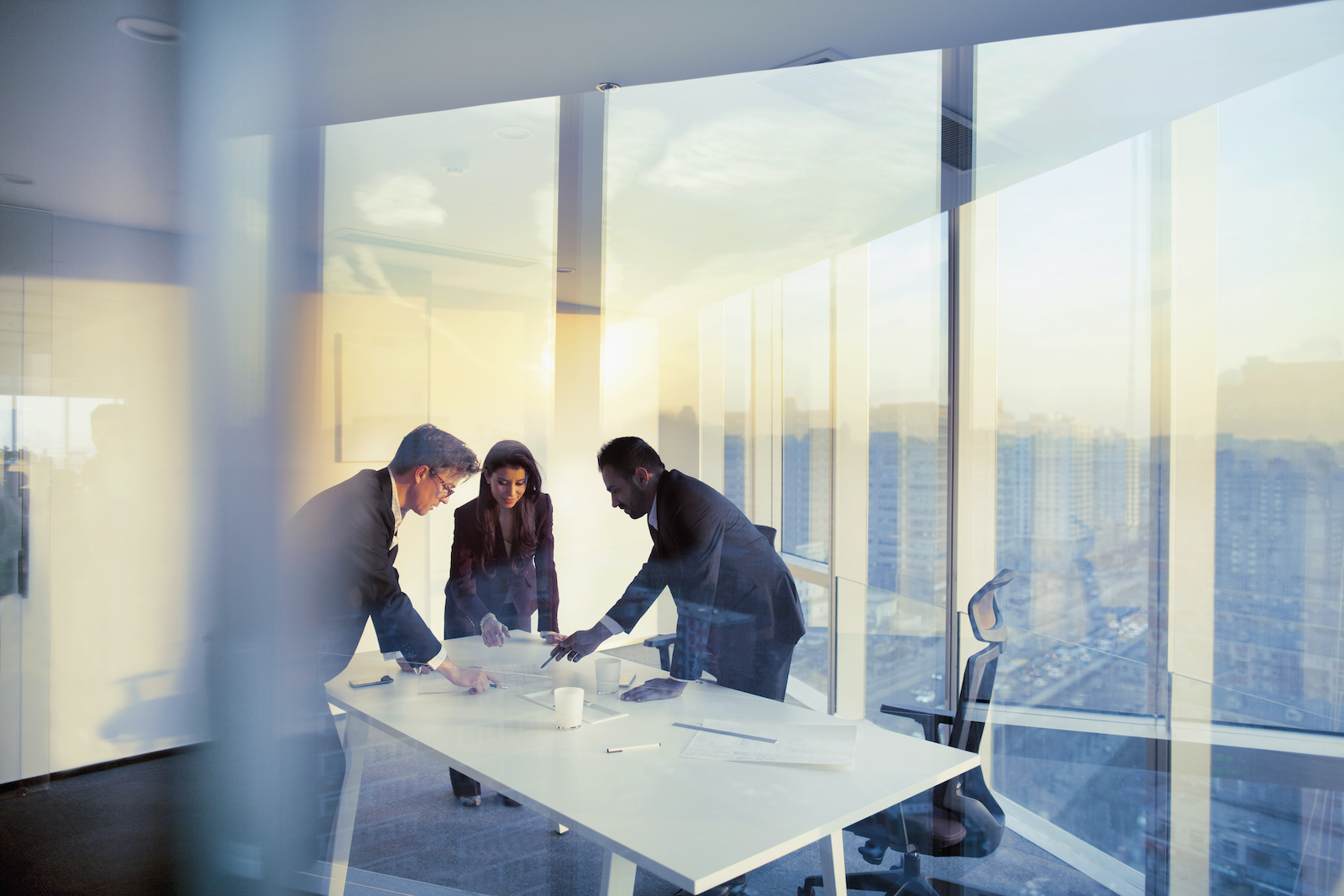 Business people gather in a conference meeting room to discuss a plan.