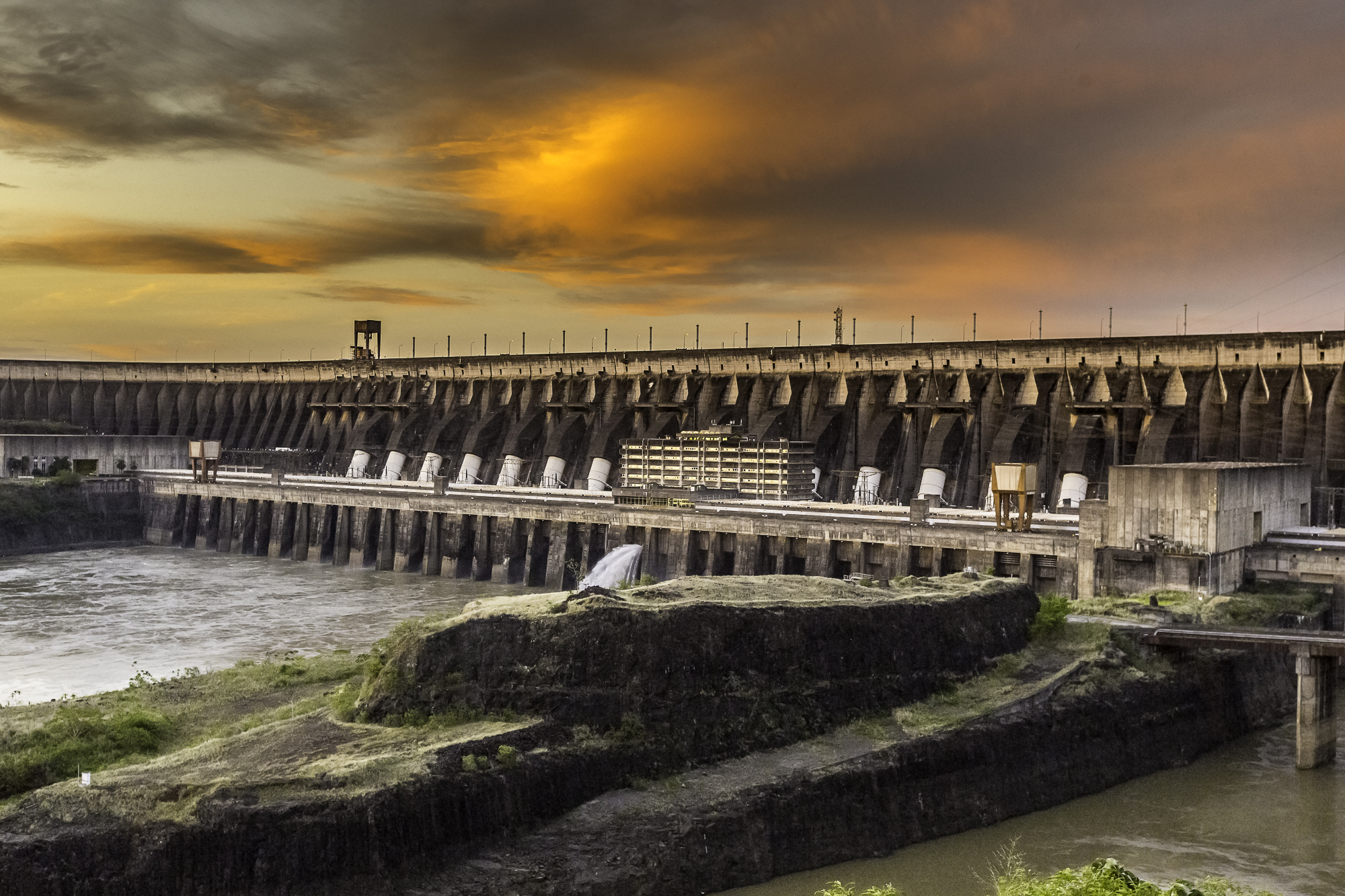 The Itaipu Dam, between Brazil and Paraguay, is shown at sunset.
