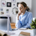 An employee at their desk and deep in thought.