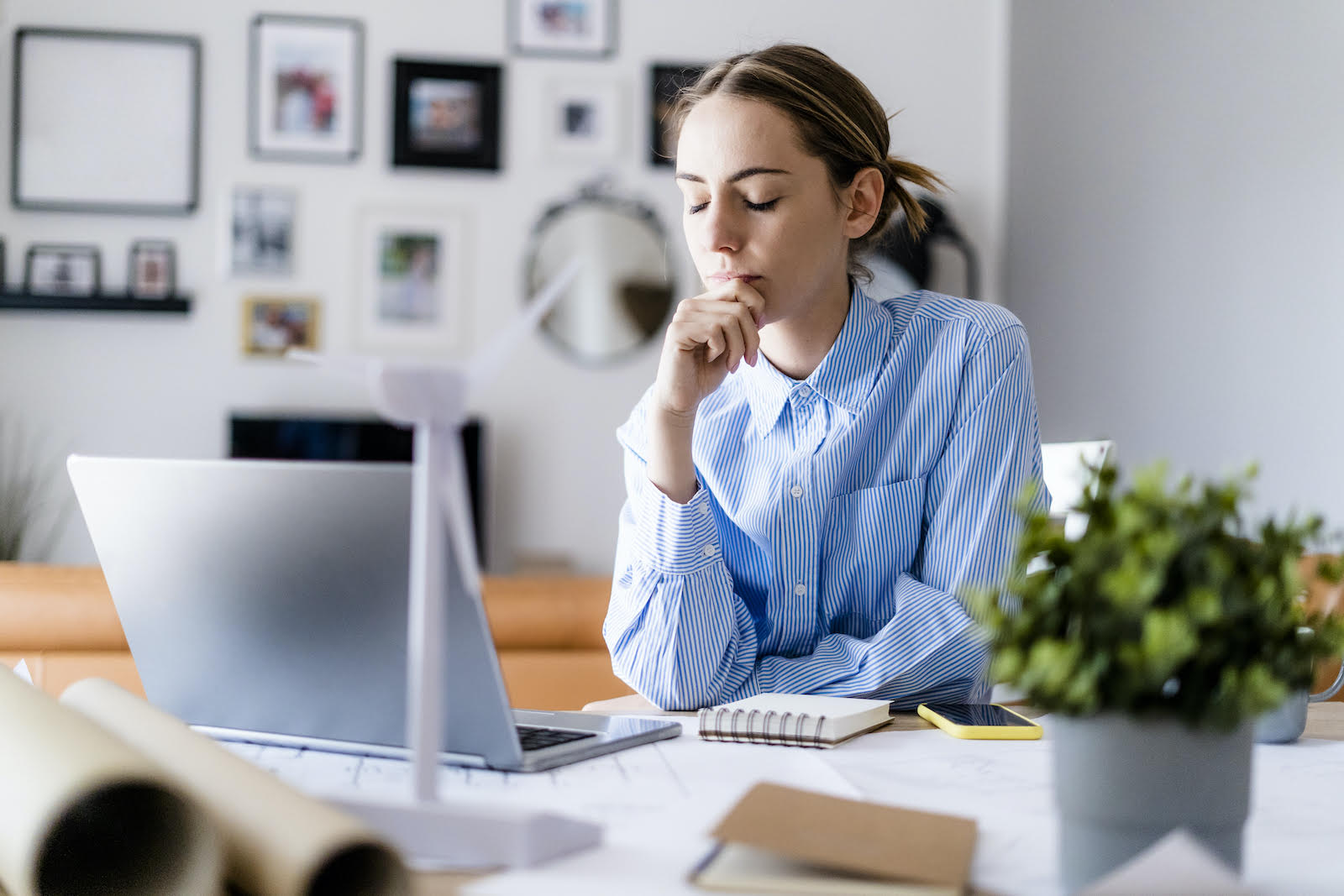 An employee at their desk and deep in thought.