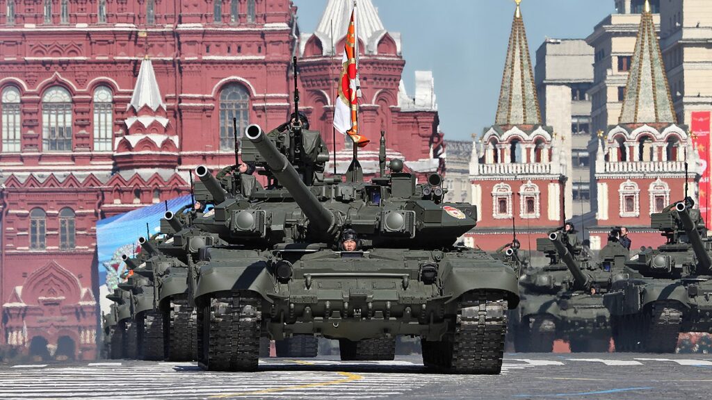 A line of tanks with soldiers drive through Red Square in Moscow, Russia.