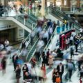 The inside of a British train station, with shops and blurred people moving around