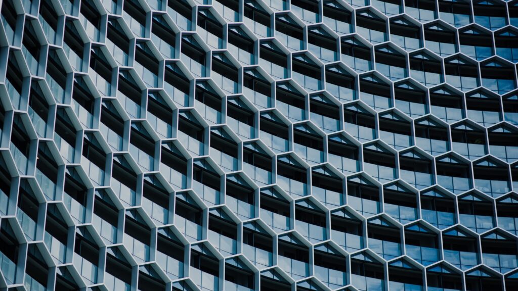 An abstract image of a grey building with a repeating hexagonal pattern.