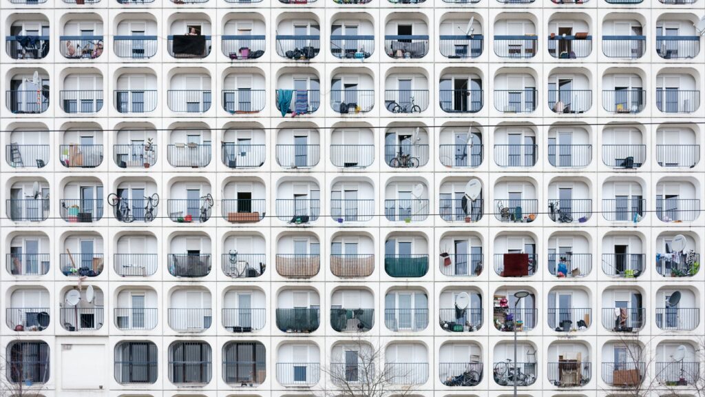 A white apartment building with rows and rows of identical balconies.