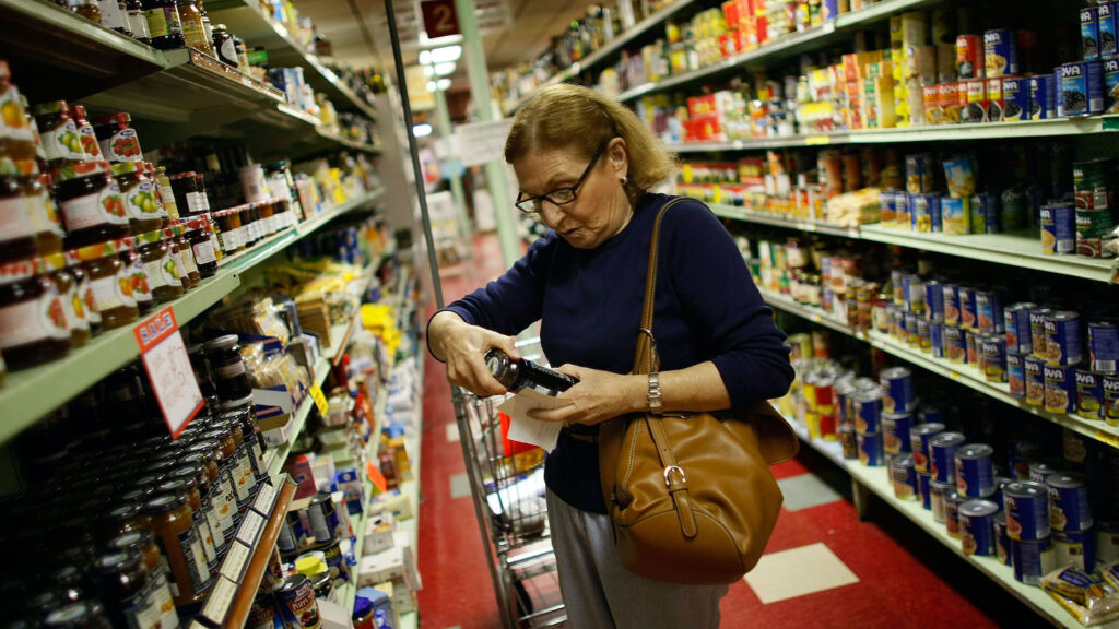 A shopper reads a product label at Lorenzo's Supermarket in North Miami.