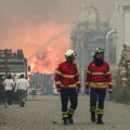 Firefighters walk away from a wildfire burning in Portugal.