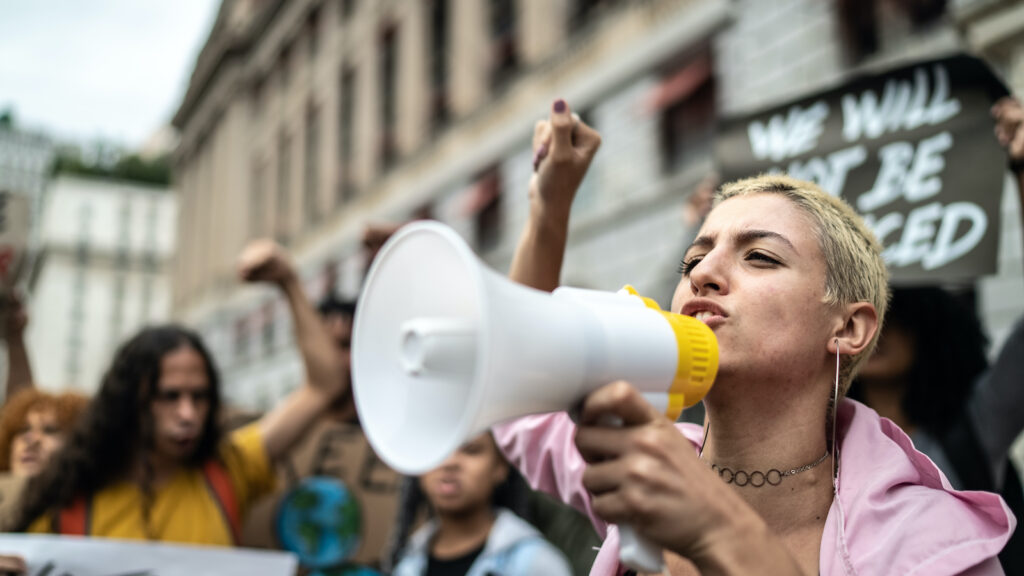 Young person leading a demonstration using a megaphone