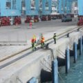 Port staff work at the edge of a dock.