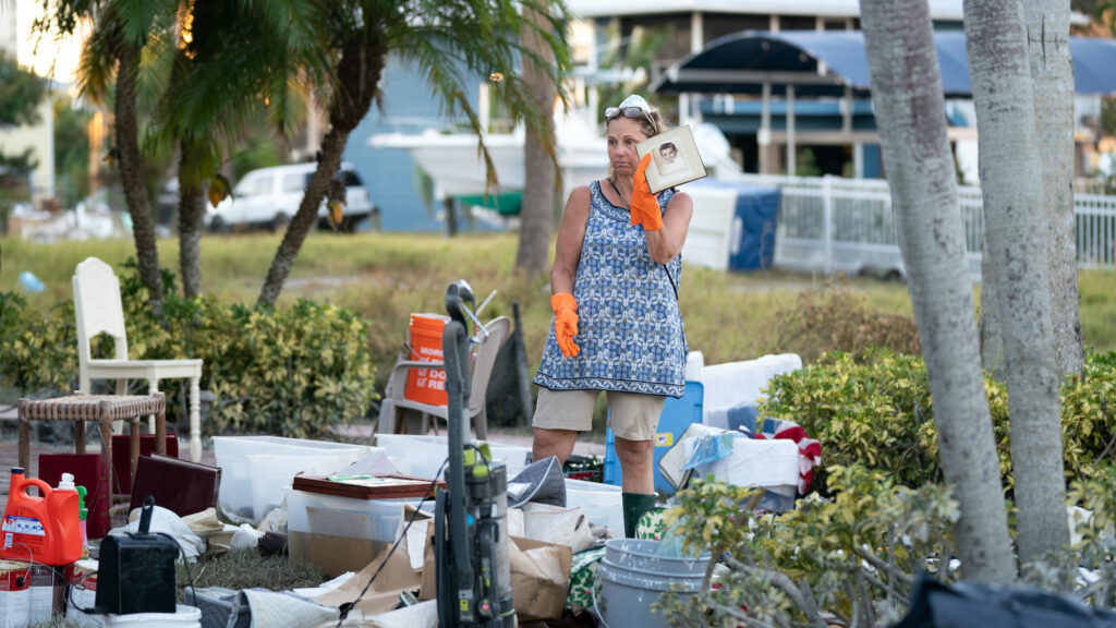 Jane Cihon sorts through family photos damaged by storm surge from Hurricane Ian on October 2, 2022