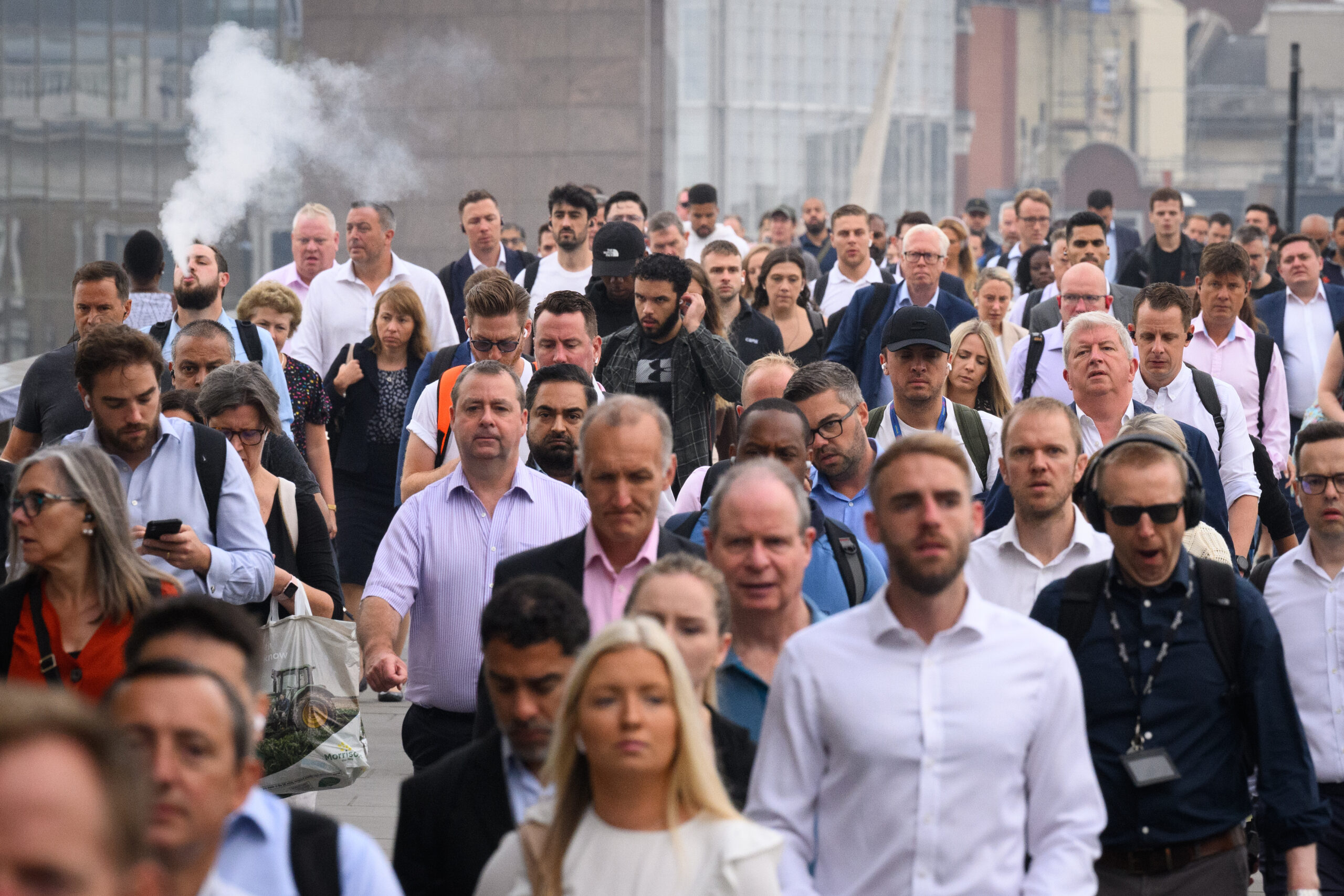 Commuters cross London Bridge during the morning rush hour on August 17, 2022 in London, England.