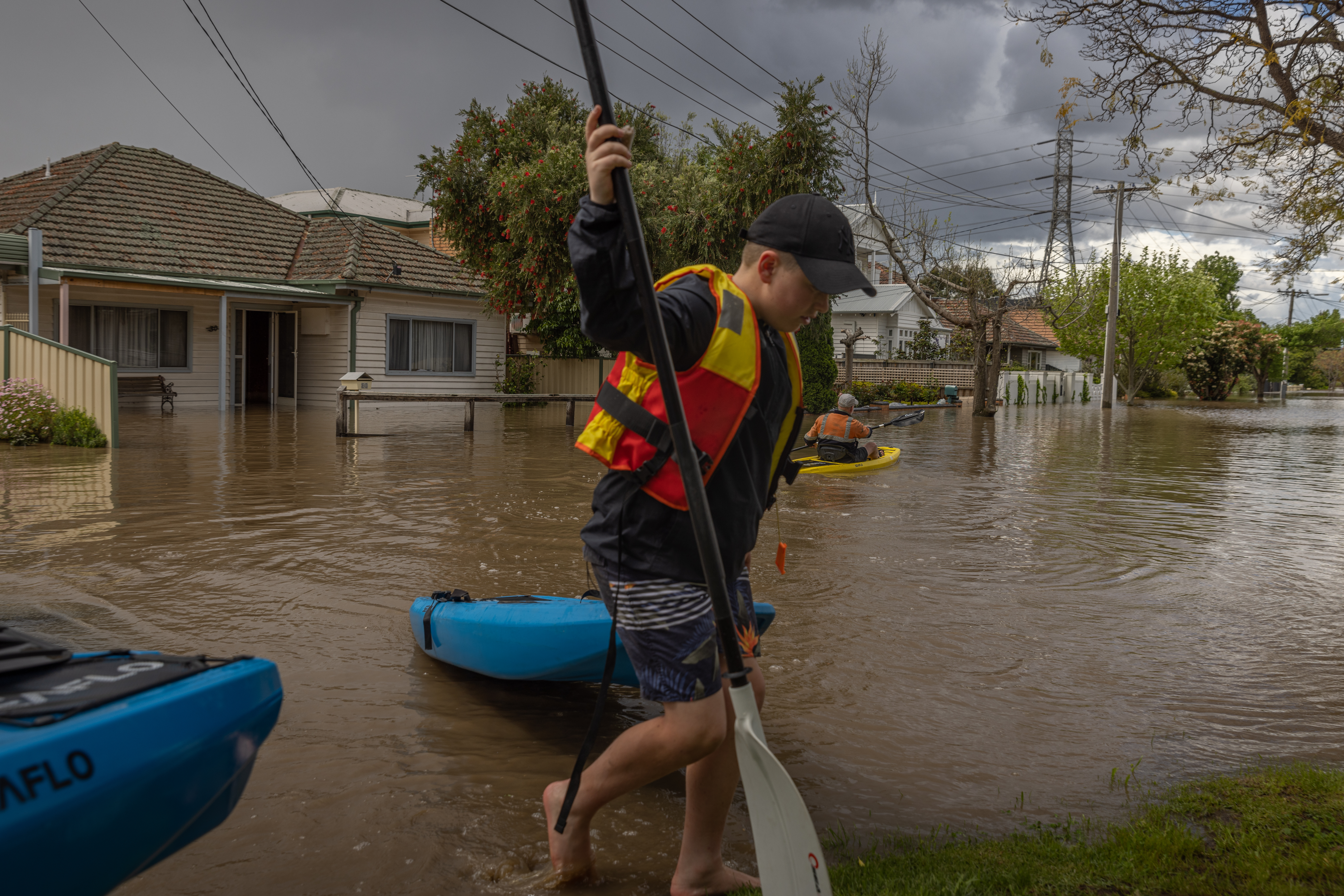 A resident canoeing down a flooded street