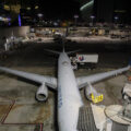 A United plane sits in a hangar at night, seen from above.