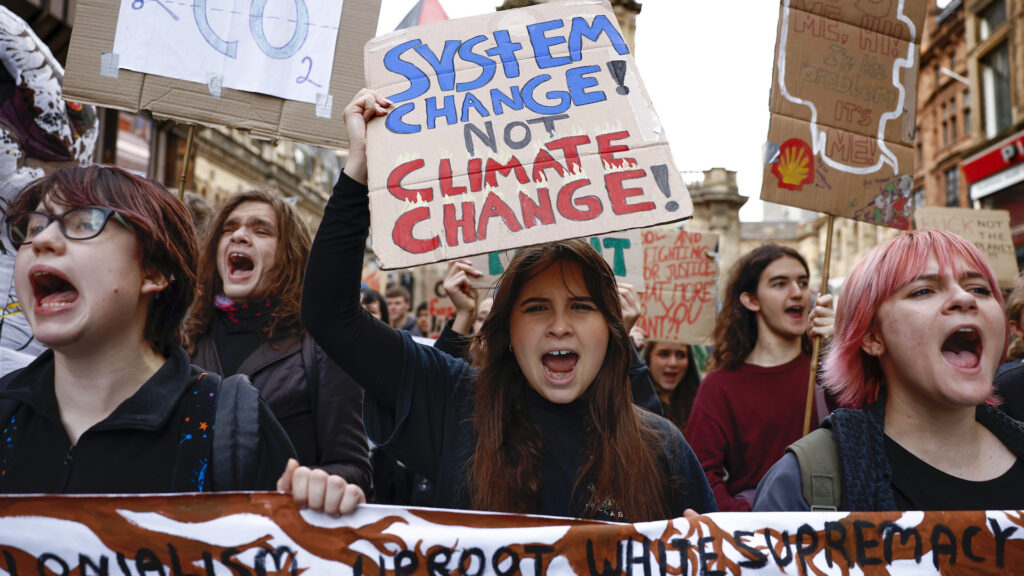 A teenage girl holds a sign that says 