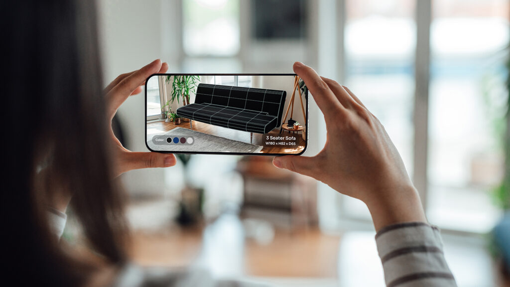 Over the shoulder view of young woman buying furnitures with augmented reality technology on smartphone