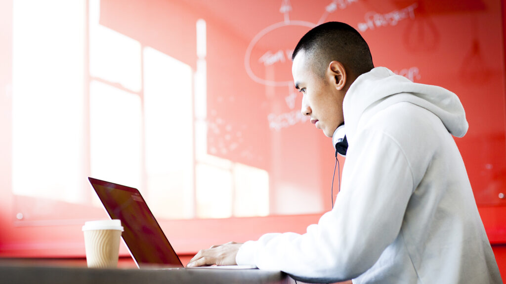 Young asian man working on his laptop computer