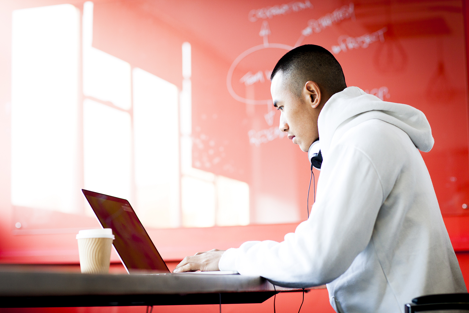 Young asian man working on his laptop computer